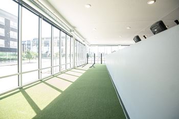 A long hallway with a green carpet and large windows.at Linc, Des Moines Iowa   